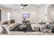 Bright living room with neutral sofas, ceiling fan, gray wood floors, tv and decorative furnishings at 14507 Woodland Spur Dr, Lithia, FL 33547