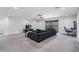 Large living room with a gray couch, carpet, ceiling fan, and sliding glass doors to the lanai at 14507 Woodland Spur Dr, Lithia, FL 33547