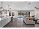 Open floor plan with kitchen island, view to living room with neutral sofa, and access to the pool at 14507 Woodland Spur Dr, Lithia, FL 33547