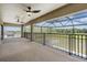 Large covered patio featuring a screened enclosure and black railings with scenic backyard views at 14507 Woodland Spur Dr, Lithia, FL 33547