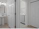 Powder room and laundry area with a pedestal sink, tile floors, and a white washing machine at 16030 Bella Woods Dr, Tampa, FL 33647