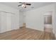 Bright bedroom featuring wood-look floors, a ceiling fan, and an ensuite bathroom at 16030 Bella Woods Dr, Tampa, FL 33647