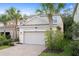 Charming home with a two-car garage, brick-paved driveway, and beautiful landscaping with palm trees at 16030 Bella Woods Dr, Tampa, FL 33647