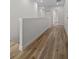 View of the upstairs hallway featuring laminate floors and access to multiple rooms at 16030 Bella Woods Dr, Tampa, FL 33647