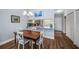Inviting dining area featuring wood floors, stylish table, and open kitchen view at 1686 Seascape Cir, Tarpon Springs, FL 34689