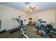 Carpeted exercise room featuring ceiling fan and treadmill and weight-lifting machine at 1686 Seascape Cir, Tarpon Springs, FL 34689