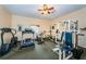 Carpeted exercise room featuring ceiling fan and treadmill and weight-lifting machine at 1686 Seascape Cir, Tarpon Springs, FL 34689