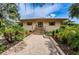 Home exterior featuring a welcoming entrance with a brick pathway and lush landscaping at 1686 Seascape Cir, Tarpon Springs, FL 34689