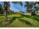 Exterior of home featuring green lawn and palm trees at 1686 Seascape Cir, Tarpon Springs, FL 34689
