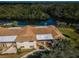 Aerial view of condo building with brown roof surrounded by lush greenery and a tranquil river view at 1686 Seascape Cir, Tarpon Springs, FL 34689
