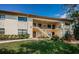Condominium exterior featuring two stories, garden landscaping, stairway, and covered walkways at 1686 Seascape Cir, Tarpon Springs, FL 34689