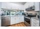 Bright kitchen with stainless steel appliances, granite countertops, and white cabinetry at 1686 Seascape Cir, Tarpon Springs, FL 34689