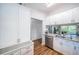 Bright kitchen featuring wood floors, white cabinets, stainless steel appliances, and granite countertops at 1686 Seascape Cir, Tarpon Springs, FL 34689