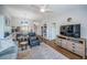 Open living room with ceiling fan, wood floors, and view into the kitchen and dining area at 1686 Seascape Cir, Tarpon Springs, FL 34689