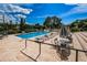 Community pool featuring brick surround, lounge chairs and umbrella tables for relaxing on a sunny day at 1686 Seascape Cir, Tarpon Springs, FL 34689