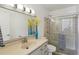 Modern bathroom with a glass-enclosed shower, contemporary lighting, and neutral tiling at 1705 Belleair Forest Dr # B, Belleair, FL 33756