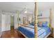 Bedroom featuring a four-poster bed, hardwood floors, and plenty of natural light at 1705 Belleair Forest Dr # B, Belleair, FL 33756