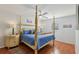 Comfortable bedroom with hardwood floors and a four-poster bed at 1705 Belleair Forest Dr # B, Belleair, FL 33756