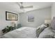 Bedroom offers neutral paint, wood floors, a ceiling fan, and window overlooking nature at 1705 Belleair Forest Dr # B, Belleair, FL 33756