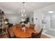 Open concept dining area featuring hardwood floors, a modern chandelier, and access to the kitchen at 1705 Belleair Forest Dr # B, Belleair, FL 33756