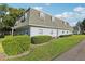 Charming exterior showing manicured lawn, mature trees, and dormer windows at 1705 Belleair Forest Dr # B, Belleair, FL 33756