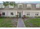 Charming condo exterior with gray paint, dormer windows, green door and well-maintained landscaping at 1705 Belleair Forest Dr # B, Belleair, FL 33756