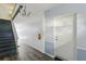 Hallway featuring carpeted stairs, stylish flooring, and modern lighting, enhancing the condo's interior at 1705 Belleair Forest Dr # B, Belleair, FL 33756
