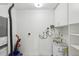 Utility room featuring water heater, vacuum, and storage shelves at 1705 Belleair Forest Dr # B, Belleair, FL 33756