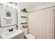 Well-appointed bathroom with modern vanity, decorative mirror, open shelving, and shower-tub combo at 1705 Cinnabar Ct, Brandon, FL 33510