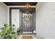 Close-up of a stylish front door with wreath and lantern, complemented by decorative plants at 1705 Cinnabar Ct, Brandon, FL 33510