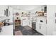 Charming kitchen with open shelving, stainless steel appliances, black hardware, and marble-look flooring at 1705 Cinnabar Ct, Brandon, FL 33510