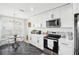 Bright kitchen features white cabinets, stainless appliances, black hardware, and black marble-look flooring at 1705 Cinnabar Ct, Brandon, FL 33510