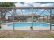 Backyard pool with a full enclosure offers shade and privacy for swimming, next to the home at 1705 Cinnabar Ct, Brandon, FL 33510
