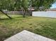 Large backyard with mature trees, a fenced perimeter and a patio, perfect for gatherings at 1713 Valencia E Dr, Largo, FL 33778