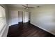 A sunlit bedroom has dark wood floors, a ceiling fan and a closet with sliding doors at 1713 Valencia E Dr, Largo, FL 33778