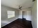 A sunlit bedroom boasts dark wood floors, a ceiling fan and a closet with sliding doors at 1713 Valencia E Dr, Largo, FL 33778