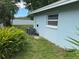 Exterior view of the home showcasing the well-maintained yard and blue paint at 1713 Valencia E Dr, Largo, FL 33778