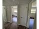 Bright hallway with doorways to bedrooms, showcasing the home's open layout and dark floors at 1713 Valencia E Dr, Largo, FL 33778