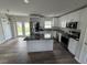 Modern kitchen featuring white cabinets, stainless steel appliances, granite countertops, and a kitchen island at 1713 Valencia E Dr, Largo, FL 33778