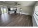 Open-concept living room and kitchen with hardwood floors, neutral paint, and a modern ceiling fan at 1713 Valencia E Dr, Largo, FL 33778