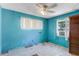 Bedroom features blue walls, a ceiling fan, and two windows at 1778 27Th N Ave, St Petersburg, FL 33713