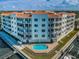 Aerial view of a waterfront condominium with a pool, spa, and balconies, showcasing its coastal lifestyle at 1860 N Fort Harrison Ave # 106, Clearwater, FL 33755