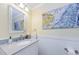 Stylish half bathroom with granite countertop, decorative mirror, and wall art at 1860 N Fort Harrison Ave # 106, Clearwater, FL 33755