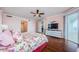 This is a bedroom with hardwood floors, pink walls, and a door to the balcony at 1860 N Fort Harrison Ave # 106, Clearwater, FL 33755