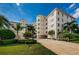 Luxury condominium exterior featuring lush landscaping, palms, red tiled roof, and a private entrance at 1860 N Fort Harrison Ave # 106, Clearwater, FL 33755