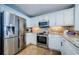 Modern kitchen featuring stainless steel appliances and white cabinetry with granite countertops and tile flooring at 1860 N Fort Harrison Ave # 106, Clearwater, FL 33755