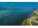 Expansive waterfront view, showcasing the natural beauty of the water and coastline with a distant boat speeding by at 1860 N Fort Harrison Ave # 106, Clearwater, FL 33755