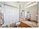 Cozy bathroom featuring decorative granite counters, sink, toilet and shower with decorative curtain at 19750 Ellendale Dr, Land O Lakes, FL 34638