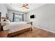 Comfortable bedroom featuring a wooden bed frame with a decorative quilt, TV, and ceiling fan at 19750 Ellendale Dr, Land O Lakes, FL 34638
