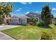 Charming home with three-car garage, manicured lawn, and lush landscaping at 19750 Ellendale Dr, Land O Lakes, FL 34638